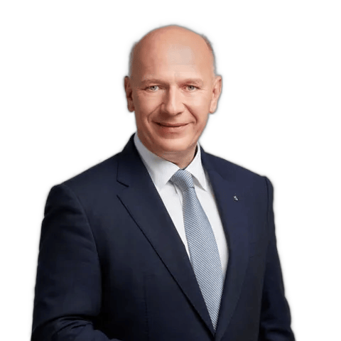 Der Regierende Bürgermeister Berlins lächelt in die Kamera. Er trägt einen dunkelblauen Anzug und eine hellgraue Krawatte.